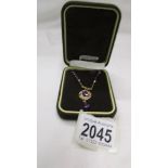 A 9ct gold pendant set purple stones.