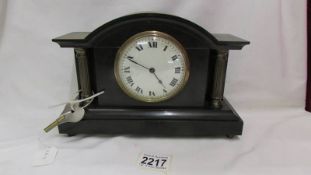 A small black slate mantel clock. (Collect only).