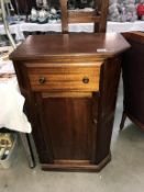 A dark wood stained cupboard with drawer