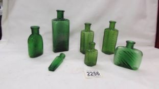 Seven assorted green bottles.