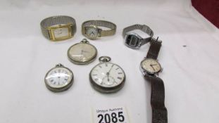 A silver fob watch, a silver pocket watch, another pocket watch and four wrist watches.