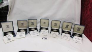 A collection of seven boxed silver proof one pound coins.