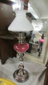 A telescopic 'candlestick' oil lamp with cranberry glass font. (collect only).