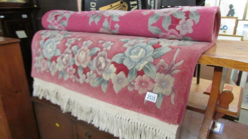 A good quality pink wool rug. (Collect only).
