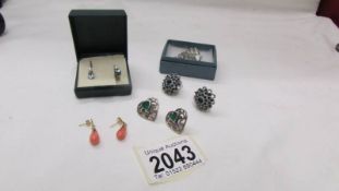 A pair of silver earrings and three other pairs of earrings.