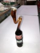 A novelty 250ml Coca Cola shaped bottle