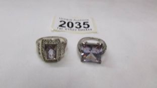 Two silver rings set amethyst coloured stone.