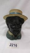 A 19th century tobacco jar in the form of a head with straw hat. (Large chip to rim of hat).