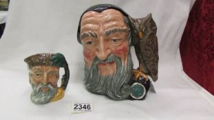 Two Royal Doulton character jugs being a large Merlin and a smaller Robinson Crusoe example.