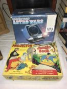 A boxed Grandstand Astro Wars game and boxed Jungle Book Give-A-Shove projector and slides