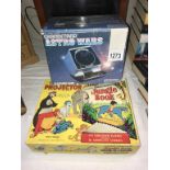 A boxed Grandstand Astro Wars game and boxed Jungle Book Give-A-Shove projector and slides
