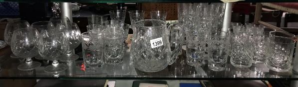 A good selection of drinking glasses with some sets of 6's and 4's and a jug