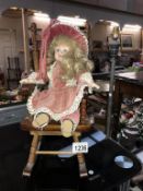 A dolls rocking chair and a doll