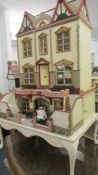 A superb three story Georgian style dolls house complete with furnishings.