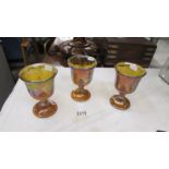 Three carnival glass goblets.