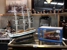 A plastic model kit assembled of a 1914 Dennie fire engine and a model of a sailing ship