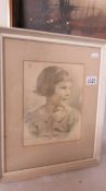 A framed and glazed pencil drawing of a young girl.