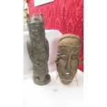 A carved hard wood tribal warrior figure and a wooden face mask.