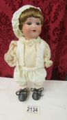 A small 19th century porcelain boy doll marked Armande Marseille, A 975 M, Germany, 410.