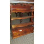 A set of mahogany shelves with drawers.