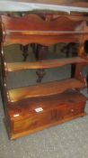 A set of mahogany shelves with drawers.