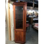 A light mahogany effect corner cupboard