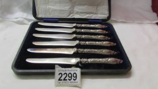 A cased set of six silver butter knives.