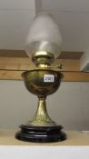A brass oil lamp on pot base complete with shade and chimney.
