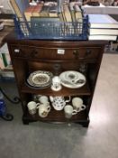 A dark wood stained small bookcase with drawer