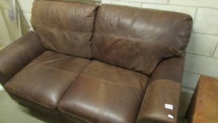 A new two seater soft brown leather sofa.