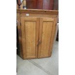 A pine corner cupboard.