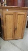 A pine corner cupboard.