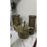 A pair of brass shell cases and a brass watering can.