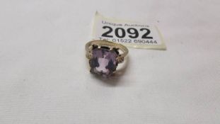 An amethyst set ring in 9ct gold with fancy set shoulders, size O.