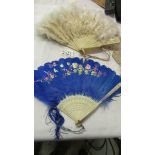 Two antique feather fans - one white and the other hand painted blue.