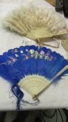 Two antique feather fans - one white and the other hand painted blue.