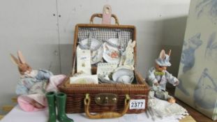 A Peter Rabbit picnic set and two rabbit figures.