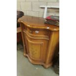 An inlaid cabinet with domed front, faded.