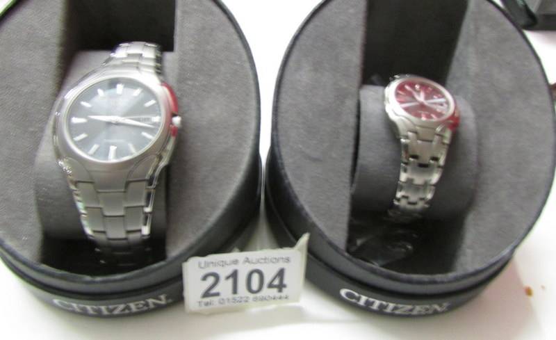 A matching pair of ladies and gent's Citizen Eco-Drive titanium wrist watches.