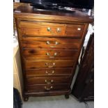 A modern mahogany narrow chest of drawers with brass handles