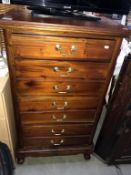 A modern mahogany narrow chest of drawers with brass handles