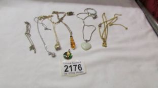 A silver chain, four pendants and an a/f yellow metal chain.