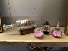 2 pink paperweights and a filigree ship in a bottle