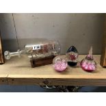 2 pink paperweights and a filigree ship in a bottle