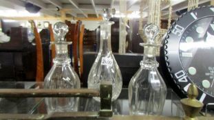 A pair of glass decanters and one other.