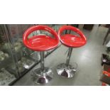 Two red and chrome retro style bar stools.