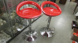 Two red and chrome retro style bar stools.