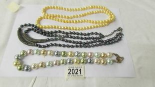 Three coloured pearl necklaces.