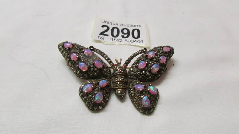 A stone set butterfly brooch in yellow metal.