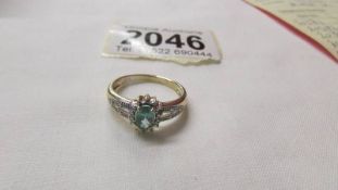 A yellow gold oval emerald and diamond ring, size M half.